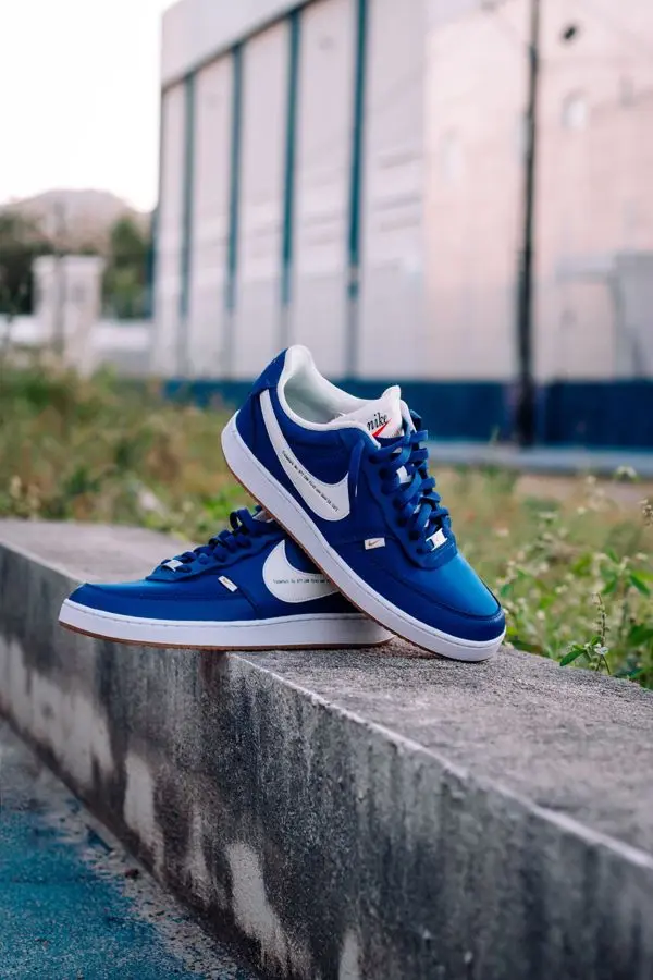Par de tenis azules sobre un muro de concreto